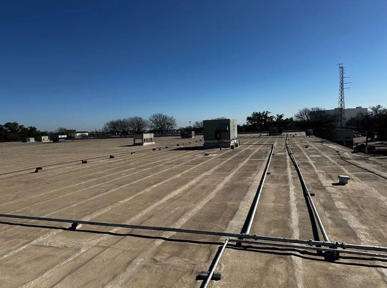 Large flat commercial roof photographed from roof level
