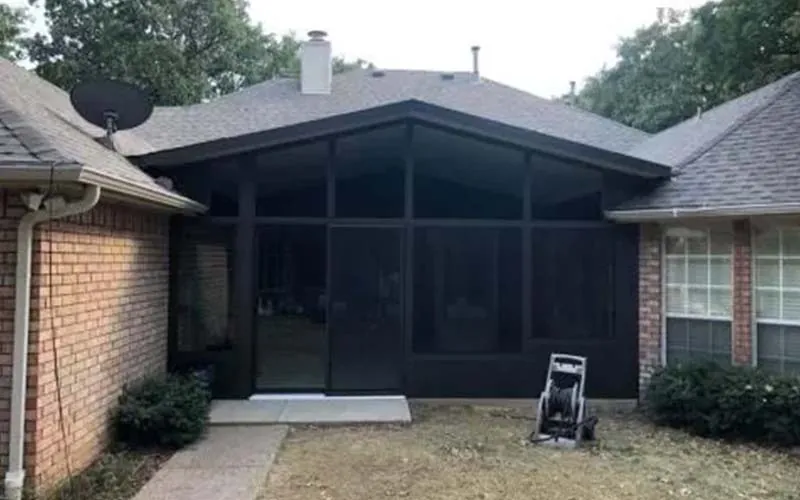 Screened sun room added to the back of a brick home