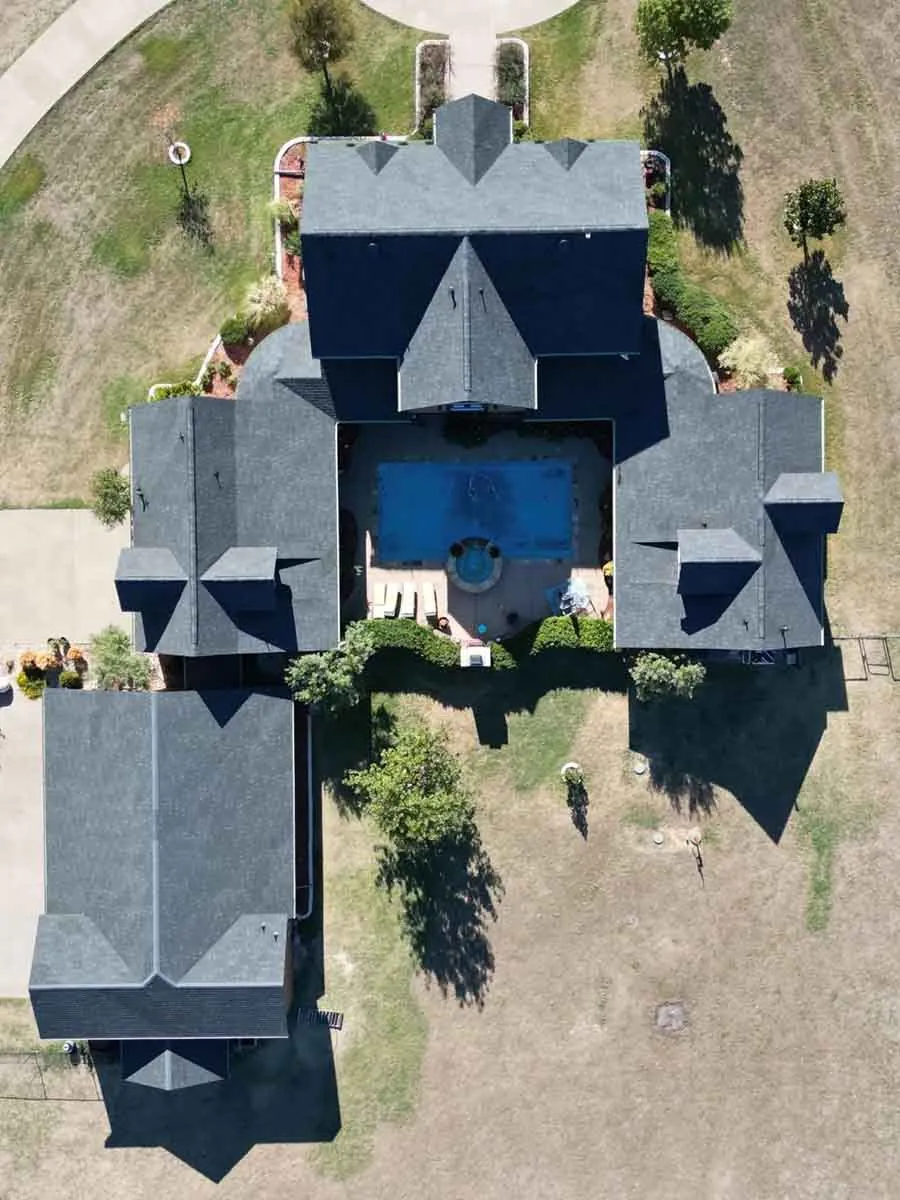 Overhead drone photo of a large home with a new dark roof