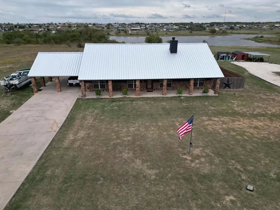 Ranch house with a white metal roof and covered porch
