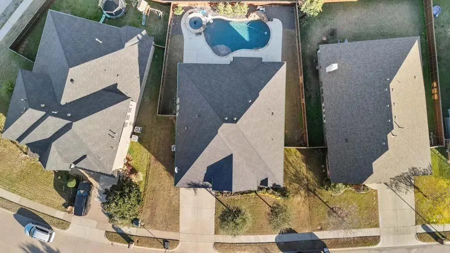 Overhead drone photo of three neighboring homes with new roofs